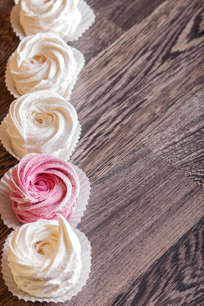 Pink and white homemade marshmallows on a gray wooden background.