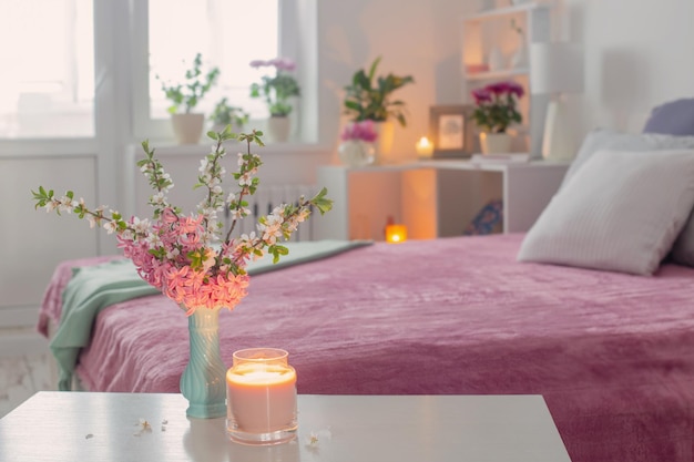 Pink and white interior of bedroom with spring flowers