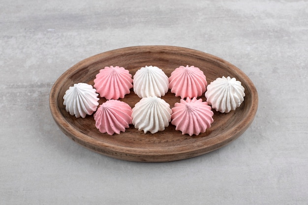 Pink and white meringue on a board, on the marble.