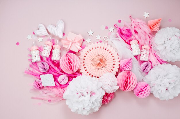 Pink and white Paper Decorations for Baby shower party. It's a Girl. Flat lay, top view