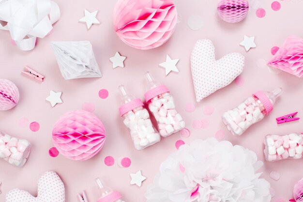 Pink and white Paper Decorations, pom-pom, candy, hearts, gifts, confetti for Baby party. Birthday concept.  Flat lay, top view