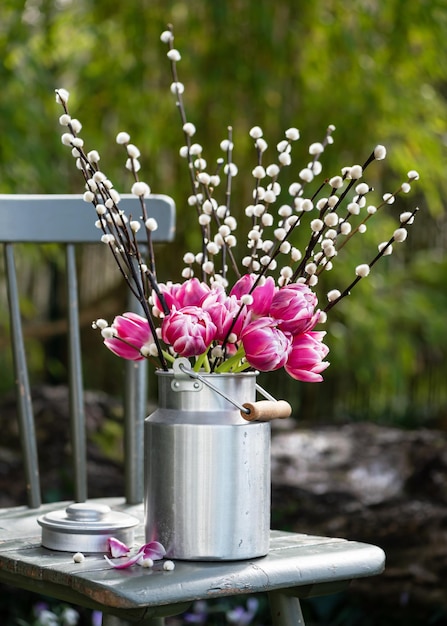 Pink white tulips and willow branches with catkins in an aluminum milk can