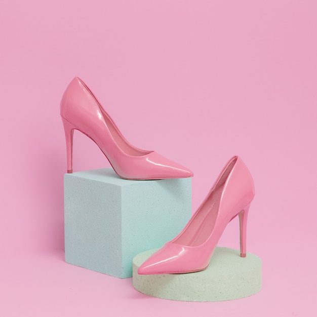 ピンクの女性の靴。パステルカラーの幾何学的空間。ファッションとグラムのコンセプト