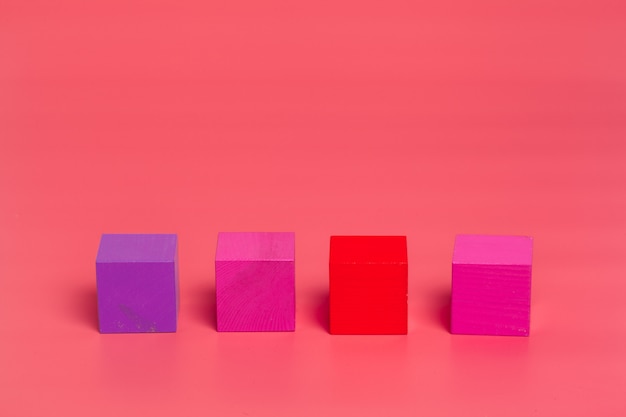 Pink wooden cubes on pink colored background