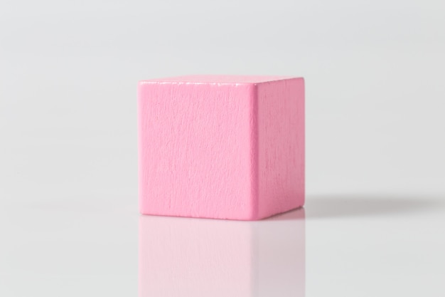 Pink wooden geometric cube isolated