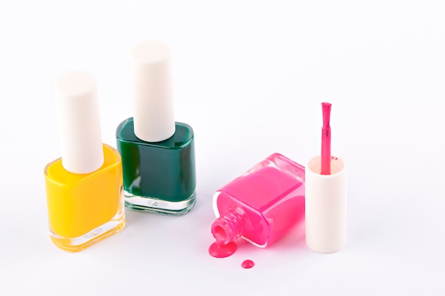 pink yellow and green nail polish on light background