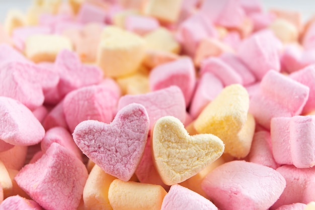 Pink and yellow heart shape mini marshmallows textures. marshmallows food background with copy space