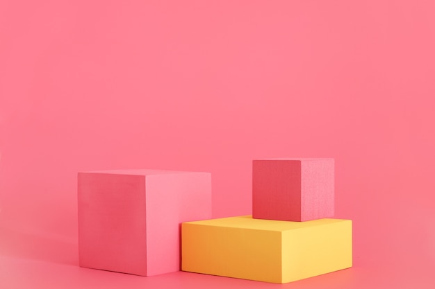 Pink and yellow podium on the pink background. Podium for product, cosmetic presentation. Creative mock up. Pedestal or platform for beauty products.