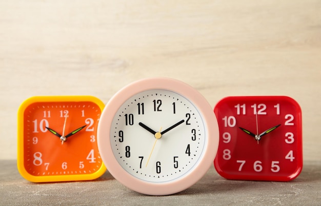 Pink yellow and red alarm clock on light background