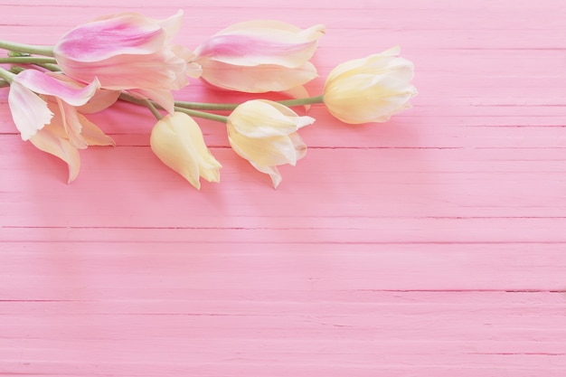 Розовые и желтые тюльпаны на окрашенных деревянных