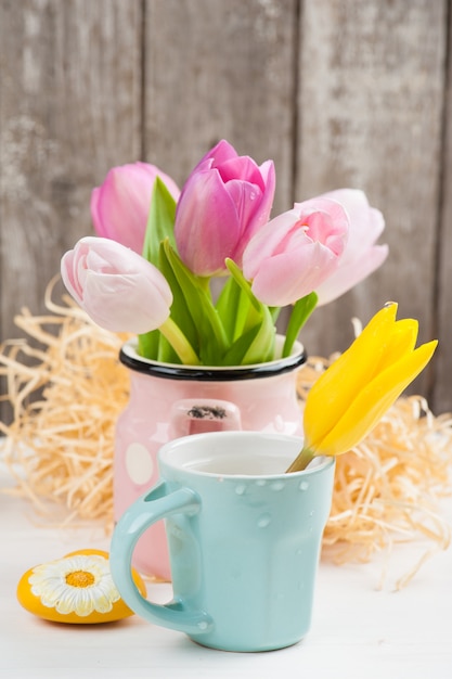 Pink yellow tulips on rustic wooden background