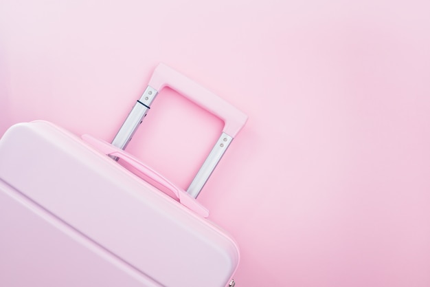 Pinky luggage on pink pastel colored for traveling concept