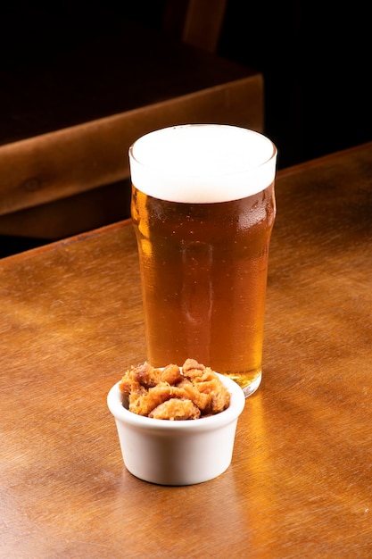 Pint of craft beer with pork rinds at happy hour