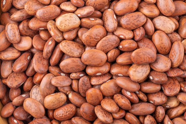 Pinto beans in a wooden bowl isolated on a white background