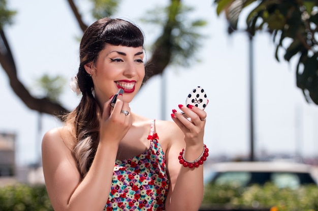 Pinup girl applying lipstick