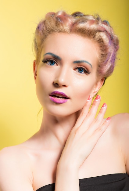 Pinup style portrait of a young beautiful woman with blue eyes and makeup