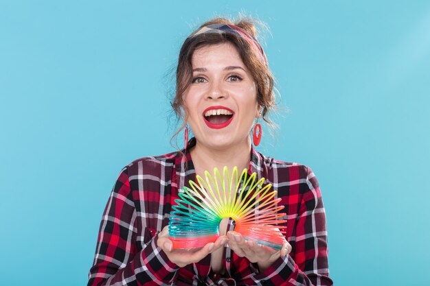 Pinup woman playing with a slinky on blue backgroud