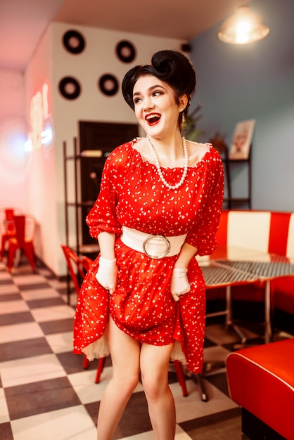 Photo pinup woman in retro cafe with checkerboard floor