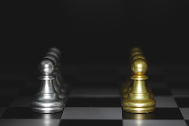 Pion schaakstukken slag, gouden en zilveren schaak op een schaakbord. concept voor strategie, zakelijke overwinning.