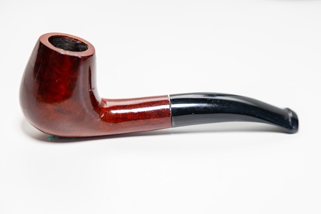 Photo a pipe with a black tip sits on a white surface.