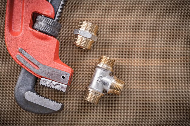 Pipe wrench brass plumbing fixtures on cleaning mesh filter grid