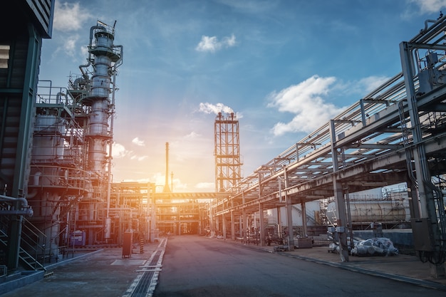 Scaffale di tubo e della conduttura dell'impianto industriale del petrolio con il cielo di tramonto