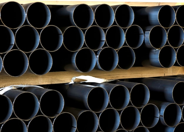 Tubi di ferro accatastati nel magazzino su pezzi di legno di grandi dimensioni