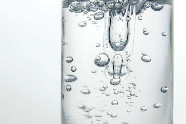 Pipette in a cosmetic serum bottle a bubble of air in a jar macro photo backlight