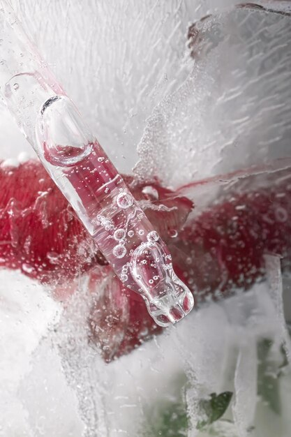 Photo pipette on a large piece of ice with frozen flowers