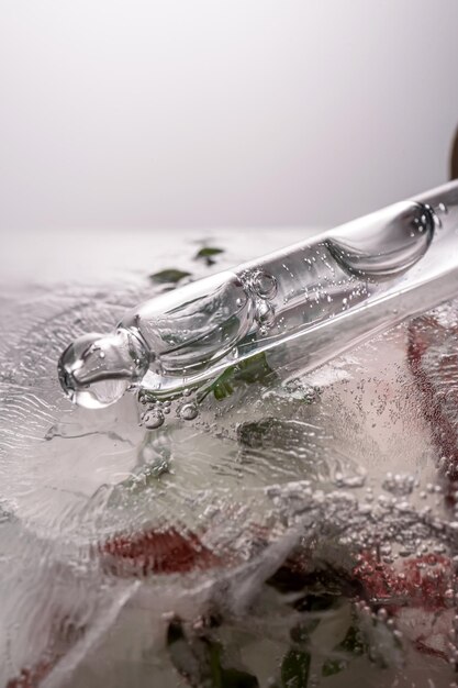 Photo pipette on a large piece of ice with frozen flowers