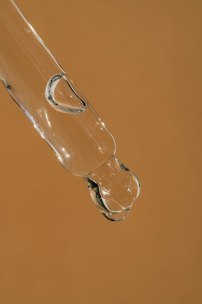 Pipette with cosmetics on a beige background