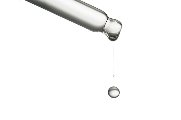 Pipette with a drop of cosmetic product on a white background