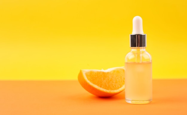 Pipette with orange essential oil over bottle and oranges. Natural medicine concept. Aromatherapy