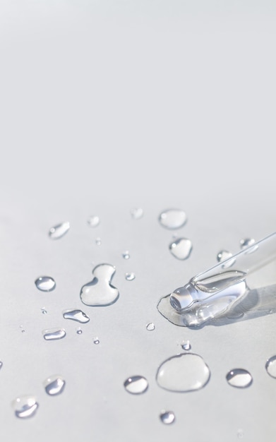 Pipette with serum or fluid hyaluronic acid on gray surface