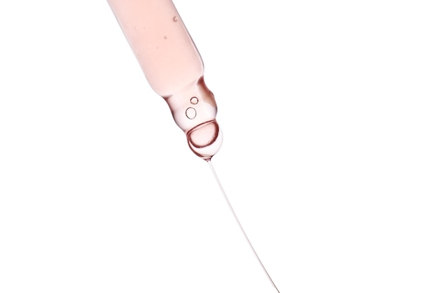 Pipette with a viscous pink cosmetic closeup