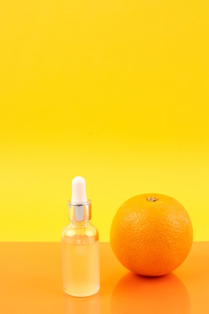 Pipetteer met sinaasappel etherische olie over fles en sinaasappels. Natuurgeneeskunde concept. Aromatherapie