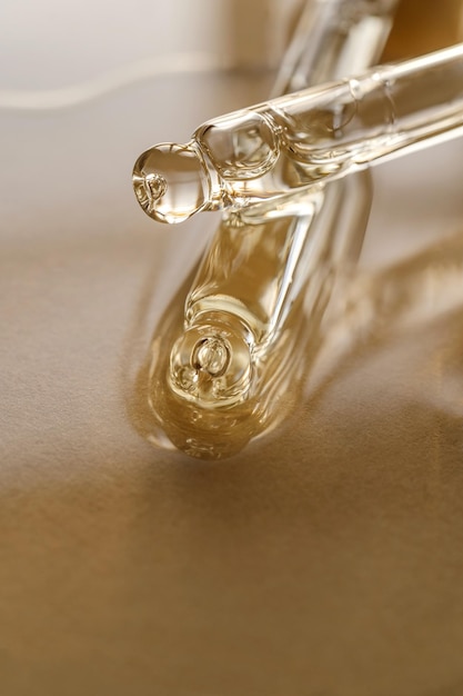 Pipettes with oil or serum on a golden background