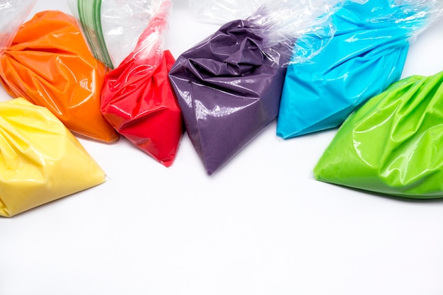 Foto sacchetti da pasticceria con glassa multicolore per la decorazione di torte o biscotti isolati su sfondo bianco