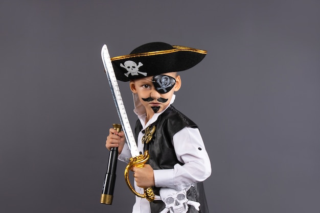 Capitano pirata con dipinto in una posa provocatoria. isolato su un muro grigio con abbondanza di spazio copia buon halloween.