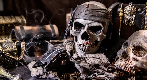 Photo pirate with human skull. treasure chest and gold. discovery equipment and explorer for disappear fortune.