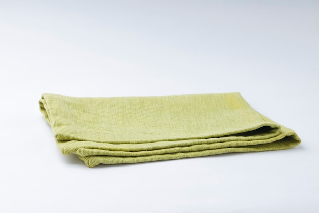 Салфетка зеленого цвета Pista, расположенная на белом текстурированном фоне, изолированном, селективном фокусе.