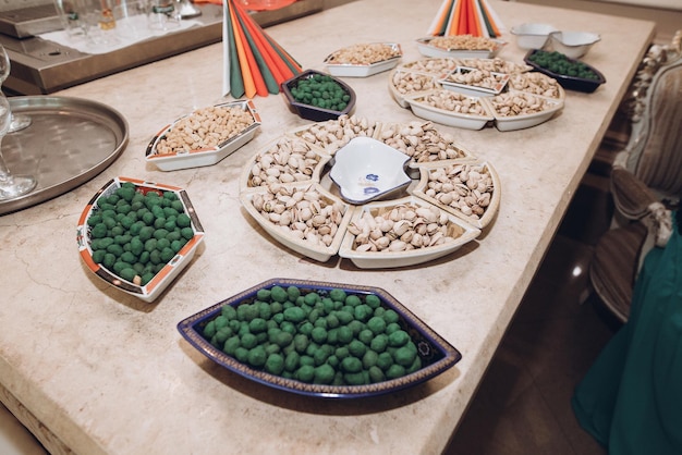 Pistache en gezouten noten op dienblad op biertafel bij huwelijksreceptie in restaurant luxe catering kerstviering