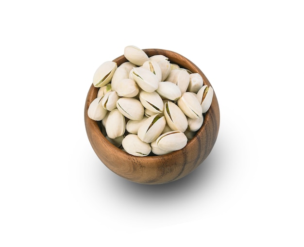 Pistachenoten in een houten kom op een wit.