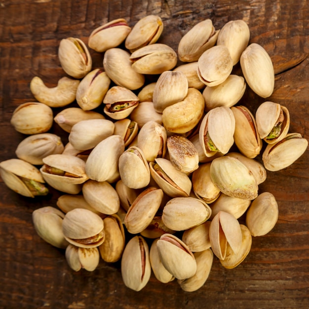 Pistachenoten in schelpen verstrooiing op een houten tafel. Vierkante foto