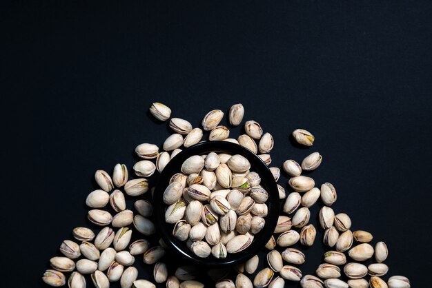 Pistachenoten noten in keramische kom op houten tafel.