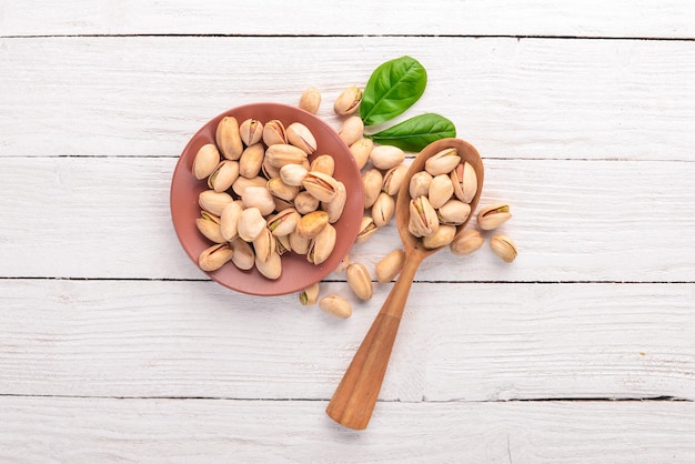 Pistachenoten noten op een witte houten achtergrond Gezonde snacks Bovenaanzicht Vrije ruimte voor tekst