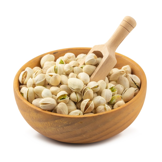 Pistachesnoten in houten die kom op een witte achtergrond wordt geïsoleerd.