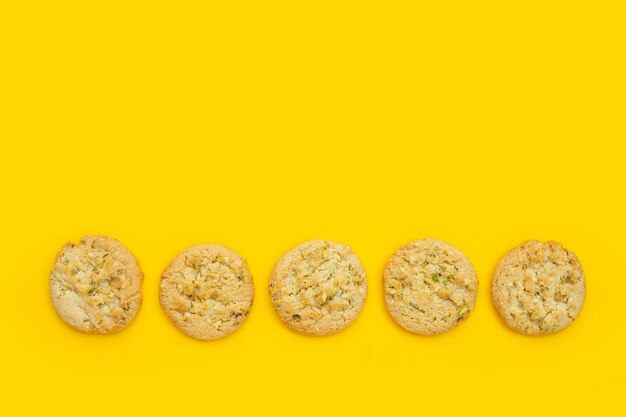 Photo pistachio and almond cookies on yellow background