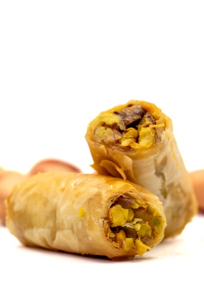 피스타치오 바클라바 (Pistachio Baklava) 는 색 바탕에 고립된 버클라바입니다.