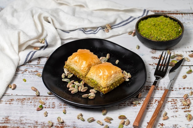 Photo pistachio baklava on a white wooden background turkish cuisine delicacies turkish baklava close up